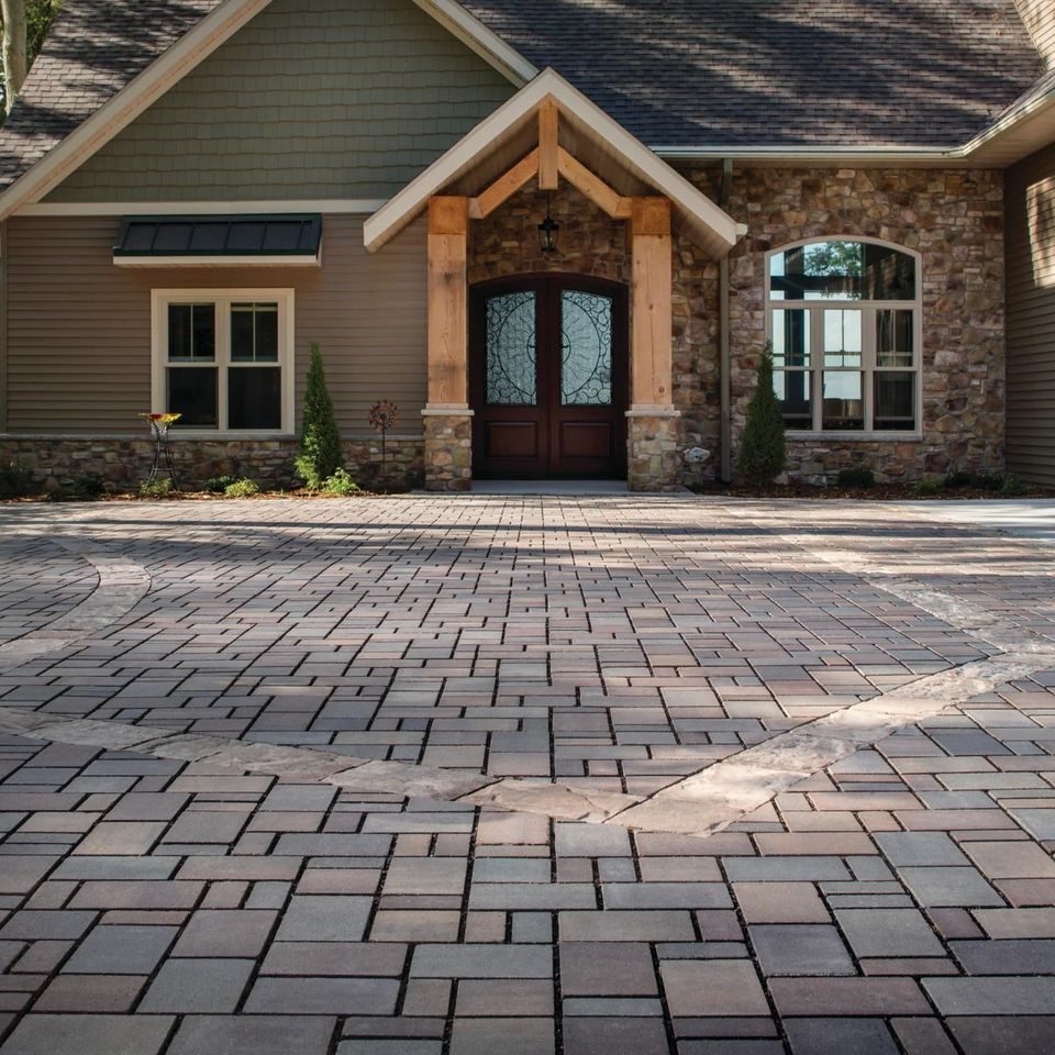 Paver driveway laid in a circular pattern in front of a craftsman-style entry