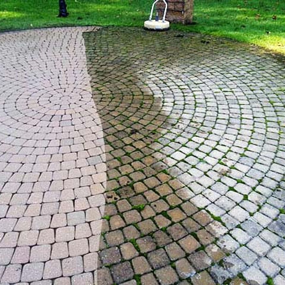 Circular paver patio with moss stripped from one half, cleaned against uncleaned