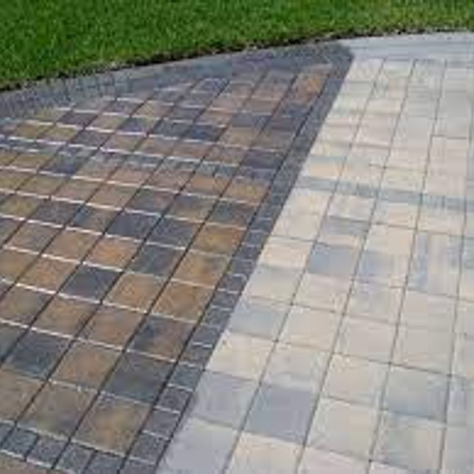 Paver patio mid-treatment, sealed colour on one side against untreated pavers on the other