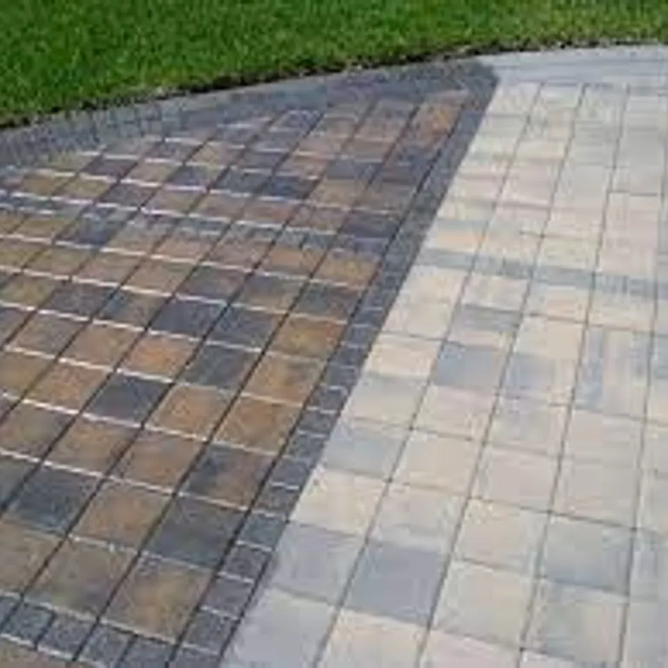 Paver patio mid-treatment, sealed colour on one side against untreated pavers on the other