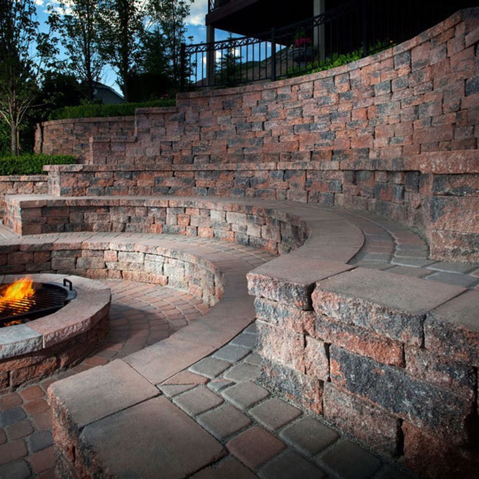 Terraced block walls curving around a fire pit to form stepped seating