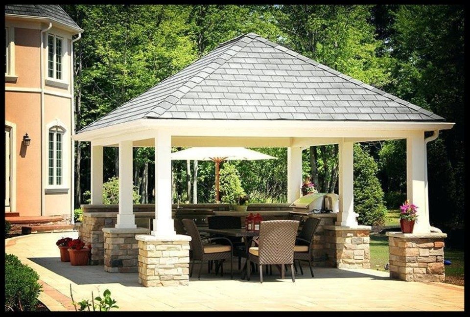 Hip-roofed garden pavilion on stone-clad columns, furnished for outdoor dining