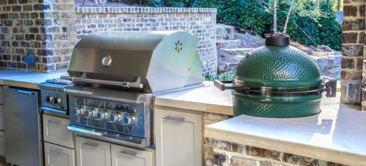Brick outdoor kitchen counter with a built-in gas grill and a kamado charcoal cooker