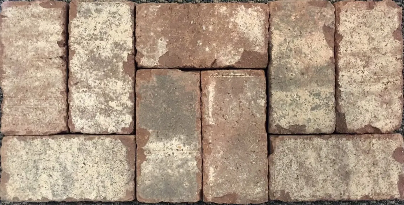 Close-up of weathered clay brick pavers laid in a basketweave pattern