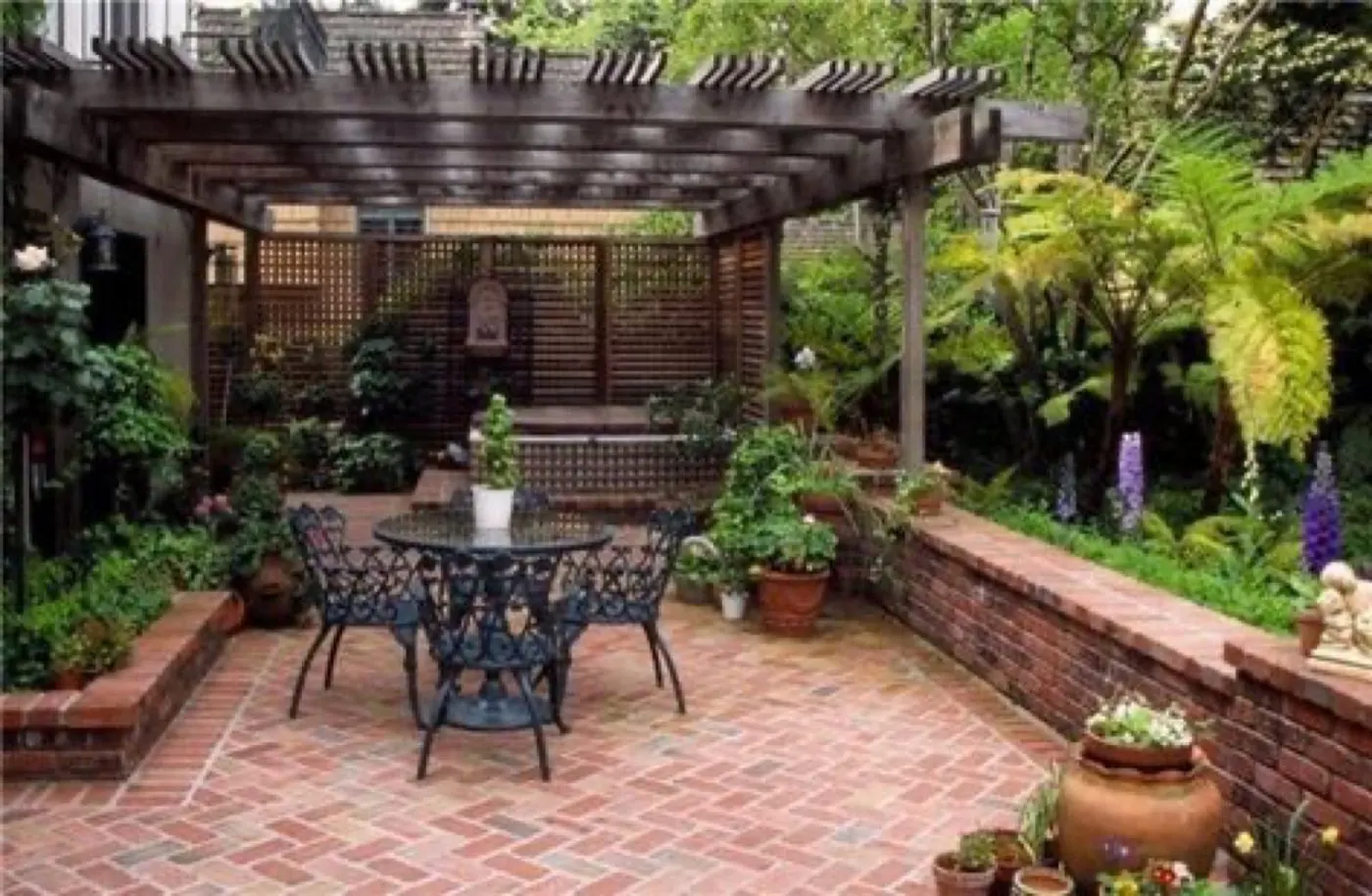 Brick courtyard patio with raised brick planter walls under a timber pergola in Huntersville