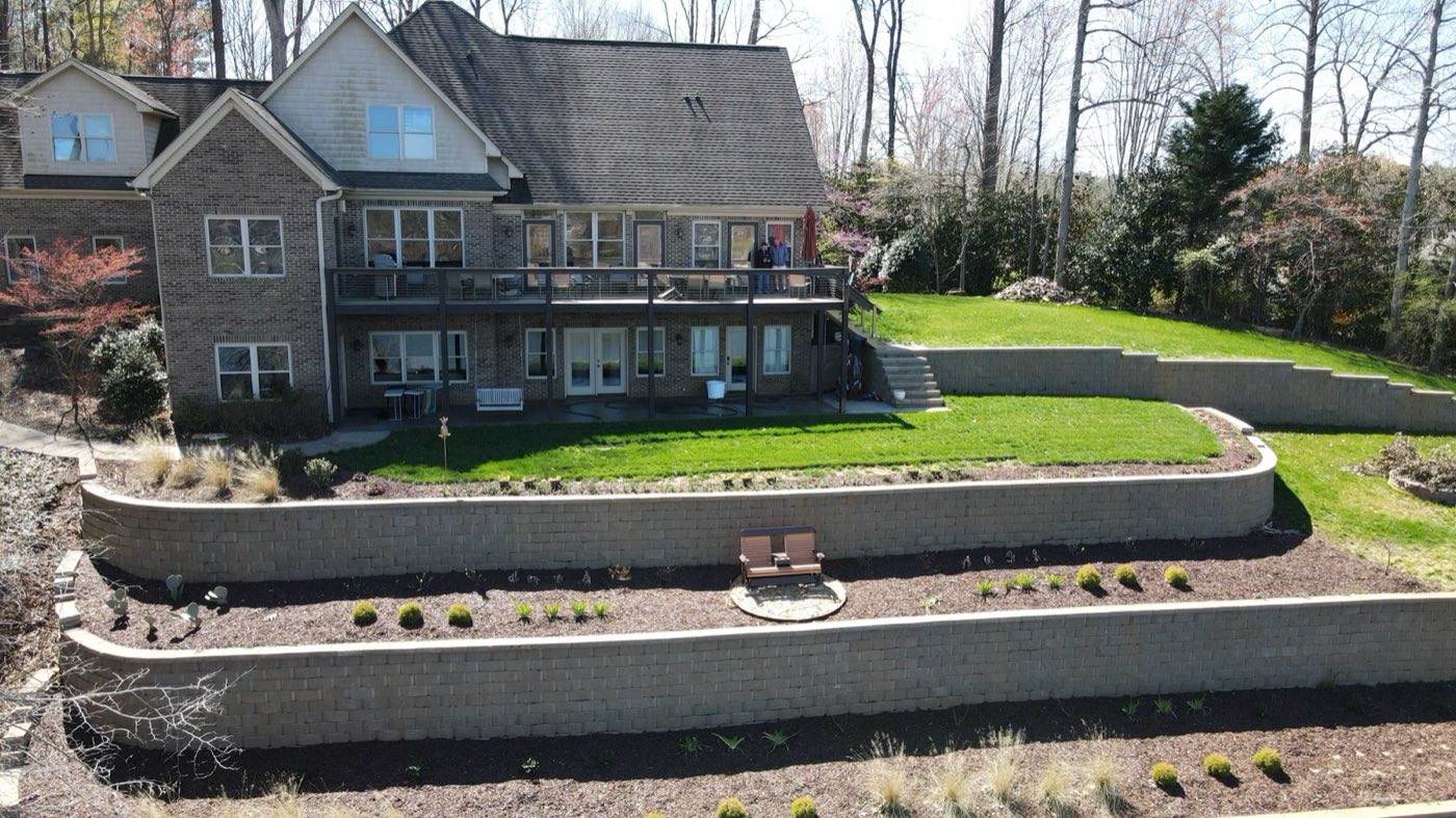 Terraced block retaining wall with planted beds on a Mooresville property