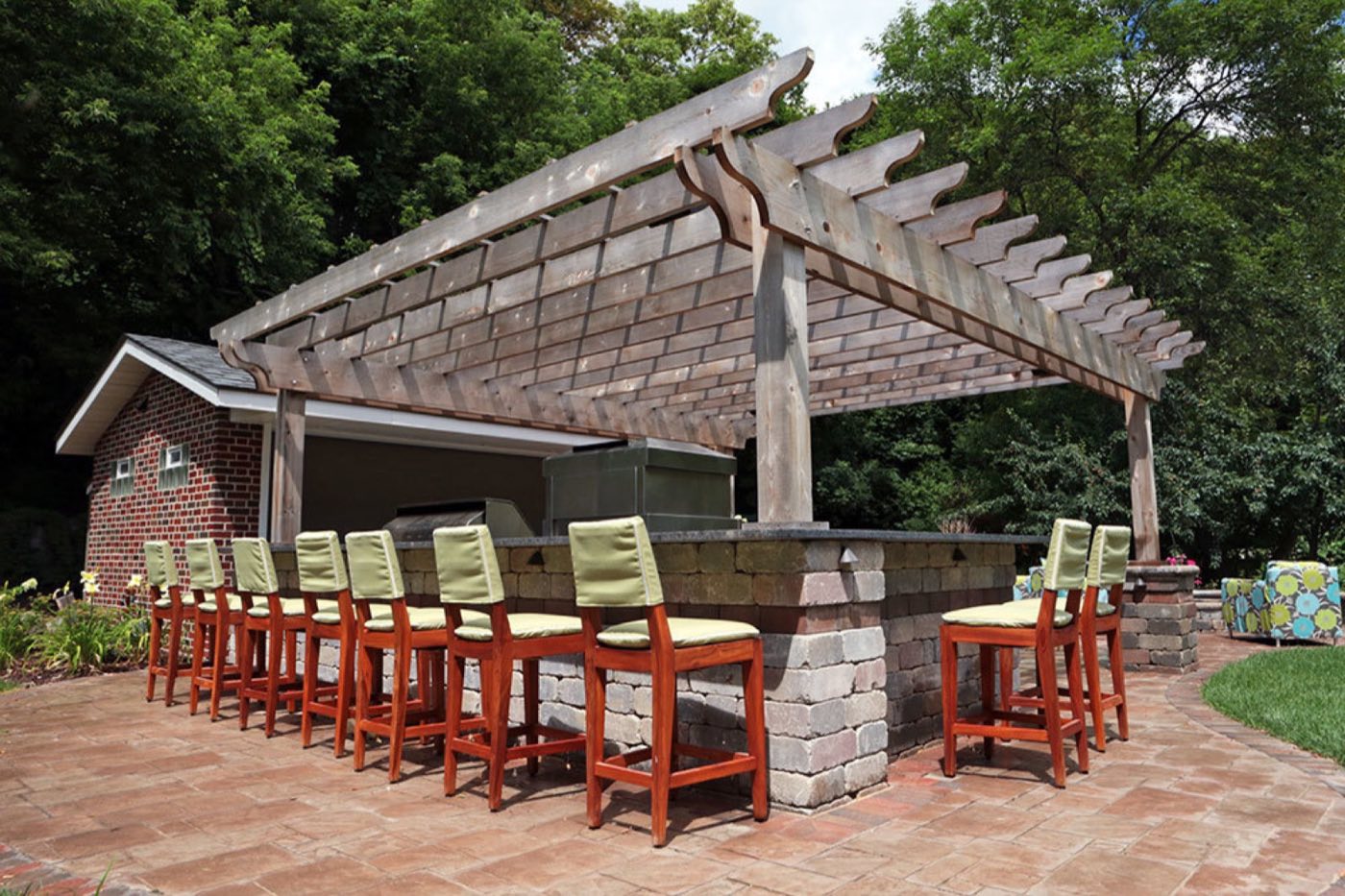 Weathered timber pergola over a long stone bar counter lined with stools